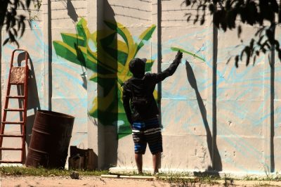 artista trabalha no muro do Campus